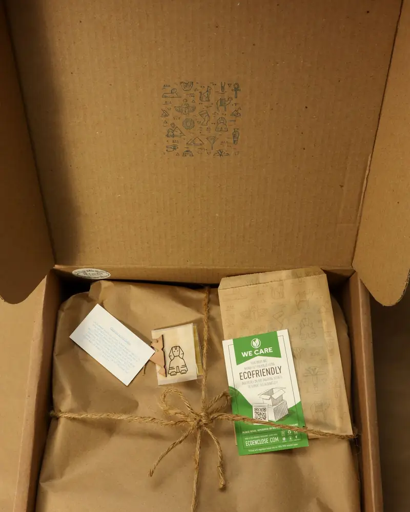 An open cardboard box containing paper-wrapped parcels.